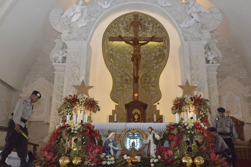 Petugas Brimob Polda Bali melakukan sterilisasi menjelang kebaktian malam Natal di Gereja Katolik Roh Kudus Katedral Denpasar, Bali. Antara Foto/Fikri Yusuf