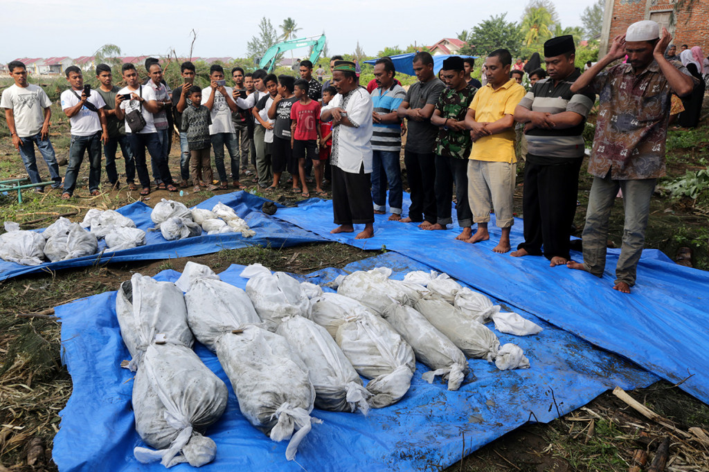 Warga menyalatkan kembali kerangka korban tsunami saat dilakukan pemindahan kuburan di Desa Kajhu, Aceh Besar, Aceh.
