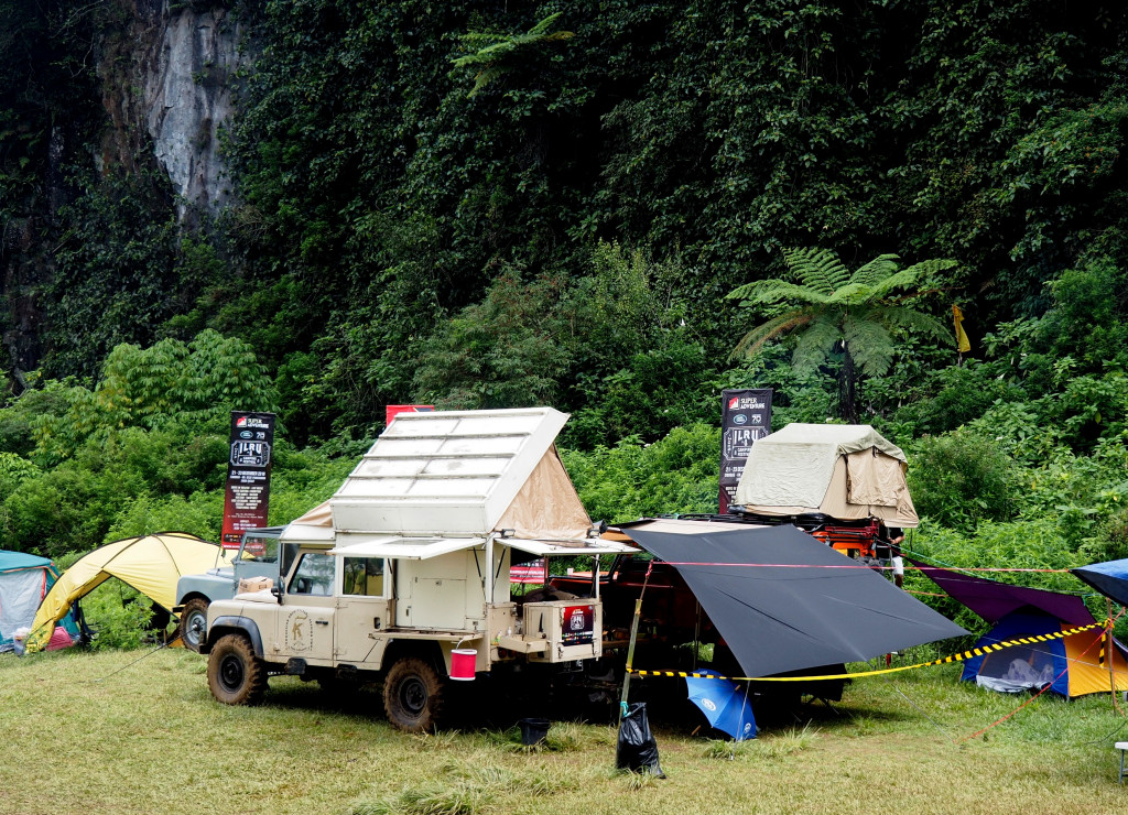Land Rover yang telah dimodifikasi sedemikian rupa menjadi camper. Tenda tempat tidur ada di atap dan dapur ada di bagian belakang.