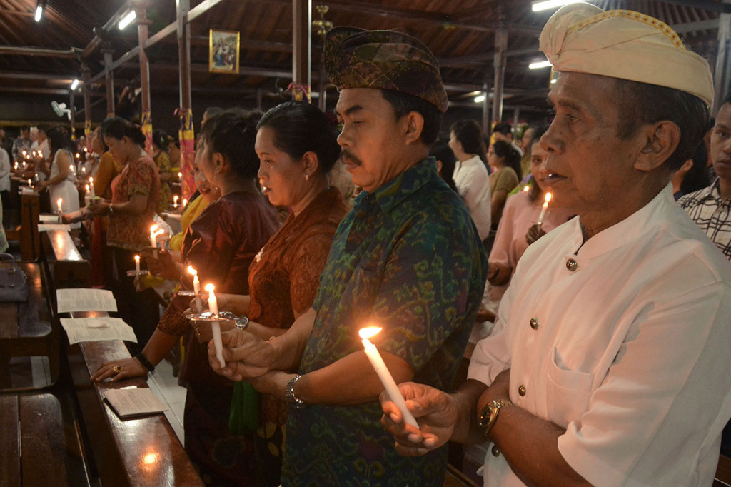 Umat Katolik mengikuti prosesi Misa Malam Natal di Gereja Katolik Tritunggal Mahakudus, Desa Tuka, Badung, Bali. Perayaan Natal di gereja tersebut menggunakan nuansa budaya Bali, seperti jemaat yang mengenakan busana adat Bali, penggunaan bahasa Bali, dan ornamen gereja berarsitektur tradisional Bali. Antara Foto/Fikri Yusuf
