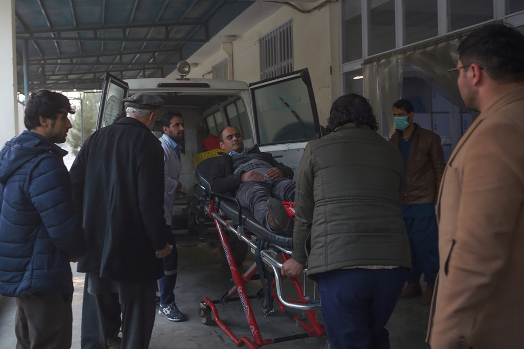 Warga membantu korban luka akibat serangan bersenjata turun dari ambulans, usai penyerangan di sebuah gedung pemerintahan di Kabul, Afghanistan.
