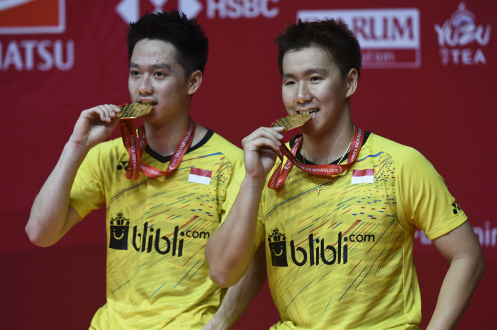 Ganda putra Indonesia Kevin Sanjaya Sukamuljo (kiri) dan Marcus Fernaldi Gideon menggigit medali emas seusai mengalahkan ganda putra Tiongkok Li Junhui dan Liu Yuchen pada babak final Indonesia Masters 2018 di Istora Senayan, Jakarta, Minggu, 28 Januari. Kevin/Marcus tampil sebagai juara setelah menang dengan skor 11-21, 21-10, dan 21-16. Ganda putra terbaik dunia tersebut sepanjang 2018 telah mengoleksi sembilan gelar juara, ditambah medali emas Asian Games. Antara Foto/Hafidz Mubarak A 