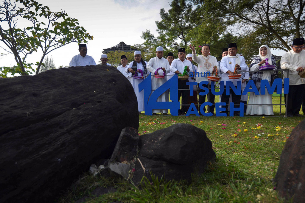 Wali Kota Banda Aceh Aminullah Usman (ketiga kanan) bersama Wali Kota Higashi Matsusima, Jepang Iwao Atsumi (keempat kanan), dan ulama serta tokoh masyarakat menabur bunga saat ziarah di Makam Tsunami Ulee Lheue, Banda Aceh. AFP/Chaideer Mahyuddin