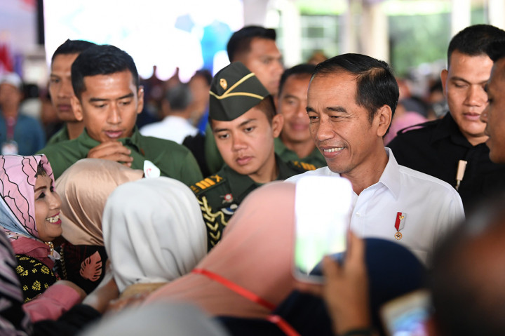 Presiden Joko Widodo menyapa warga ketika menghadiri penyerahan sertifikat tanah untuk rakyat di Cigombong, Kabupaten Bogor.