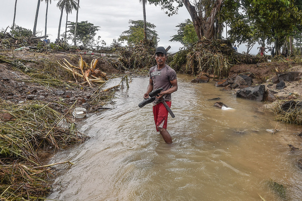 Warga berdiri di lokasi pantai yang diterjang gelombang tsunami Selat Sunda di Kecamatan Sumur, Pandeglang, Banten.
