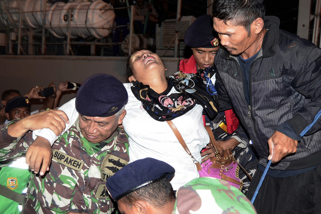 Petugas TNI AL menggendong warga korban tsunami yang berasal dari Pulau Sebesi dan Sebuku Lampung Selatan yang tak sadarkan diri setibanya di dermaga C2 Pelabuhan Panjang, Bandar Lampung, Lampung.