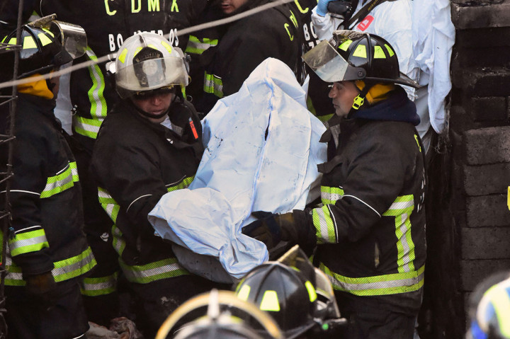 Petugas pemadam kebakaran dan petugas kepolisian mengevakuasi jenazah anak-anak korban kebakaran di lingkungan miskin di Mexico City, Jumat, 28 Desember 2018 waktu setempat.