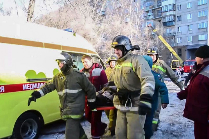 Petugas mengevakuasi korban selamat dari sebuah blok apartemen yang runtuh di Kota Magnitogorsk. 