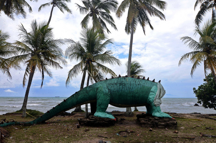Keramaian berubah menjadi kesunyian. Tsunami mengubah tawa menjadi tangis. Pantai di kawasan Cinangka, Serang, Banten menjadi sepi. Terlihat patung dinosaurus yang rusak akibat dihempas tsunami.