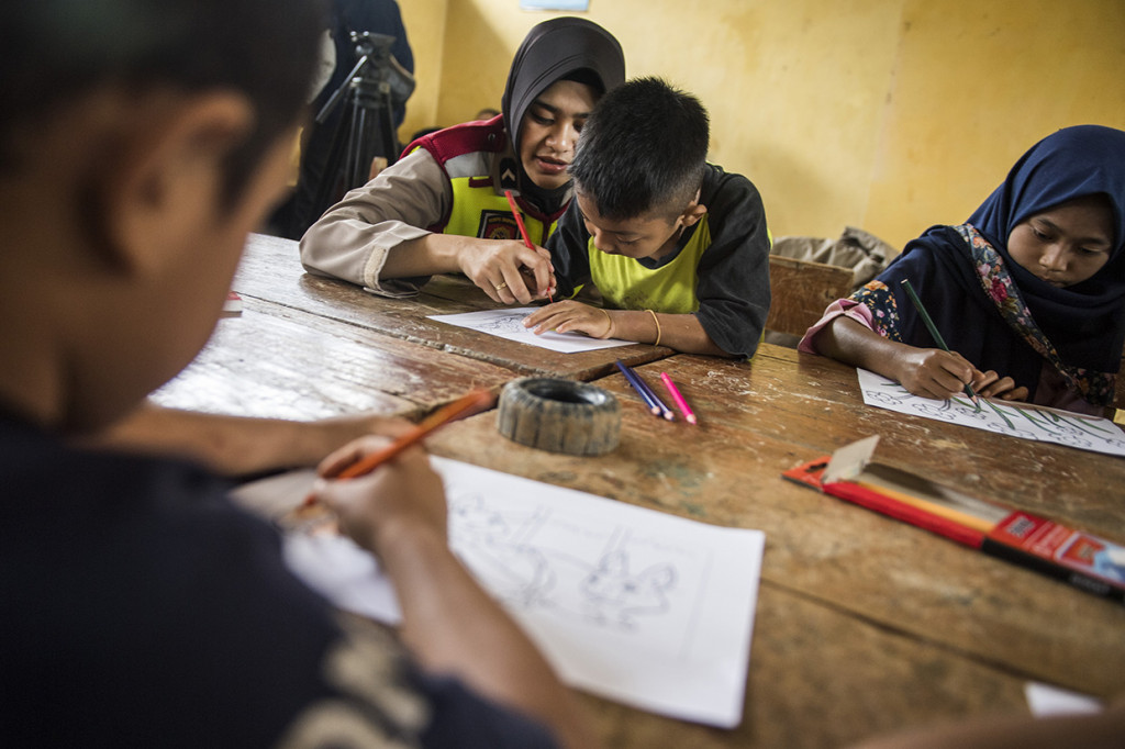 Pembimbing psikologi Polres Sukabumi mendampingi anak-anak korban bencana tanah longsor menggambar bersama di posko bencana tanah longsor di kampung Cimapag, Desa Sirnaresmi, Kecamatan Cisolok, Kabupaten Sukabumi.