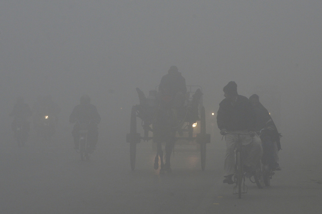 Suasana jalan di New Delhi yang diselimuti kabut tebal akibat polusi terparah. Afp Photo/Arif Ali