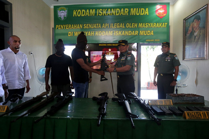 Panglima Kodam Iskandar Muda Mayjen Teguh Arief Indratmoko (dua kanan) menerima senjata api yang diserahkan warga di Mako Detasemen Intel (Denitel) Lampineung, Banda Aceh, Aceh, Kamis, 3 Januari 2019. 