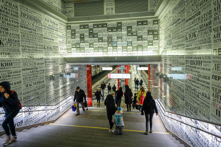 Penumpang berjalan melewati tembok yang dihiasi dengan nama-nama penulis dan penyair Rusia di stasiun metro Rasskazovka di Moskow.