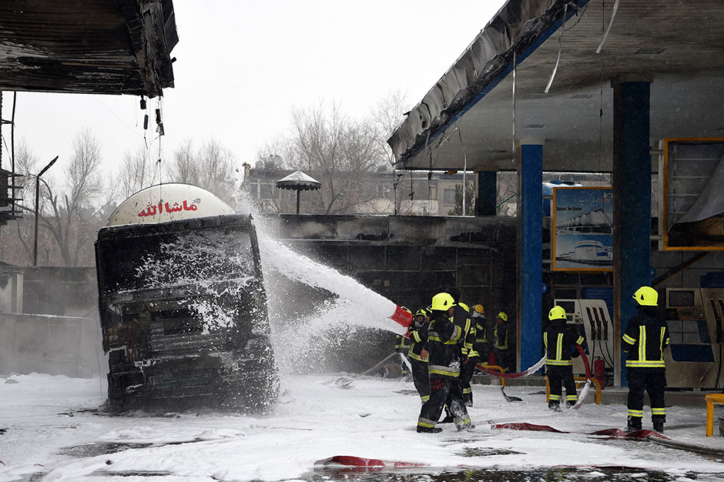 Petugas pemadam kebakaran menyemprotkan busa ke sebuah truk tanki yang turut terbakar di sebuah SPBU di Charahi Abdul Haq, Kabul, Jumat, 4 Januari 2019.