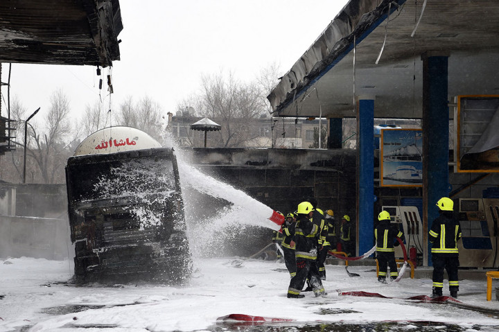 Petugas pemadam kebakaran menyemprotkan busa ke sebuah truk tanki yang turut terbakar di sebuah SPBU di Charahi Abdul Haq, Kabul, Jumat, 4 Januari 2019.