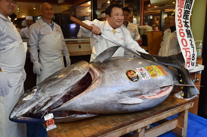 Pengusaha sushi terkenal di Jepang, Kiyoshi Kimura berpose di belakang ikan tuna sirip biru yang baru saja dia beli dalam sebuah tradisi lelang Tahun Baru di Tokyo, Sabtu, 5 Januari 2019.