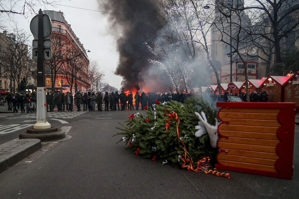 Massa 'rompi kuning' kemudian melontarkan proyektil ke polisi. Tindakan itu kemudian dibalas polisi dengan gas air mata. Afp Photo/Zakaria Abdelkafi