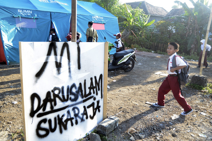 Siswa SD Yayasan Madrasah Ibtidaiyah (MI) Darussalam Sukaraja datang ke sekolah yang menggunakan tenda darurat di Desa Sukaraja, Kabupaten Lampung Selatan, Lampung.