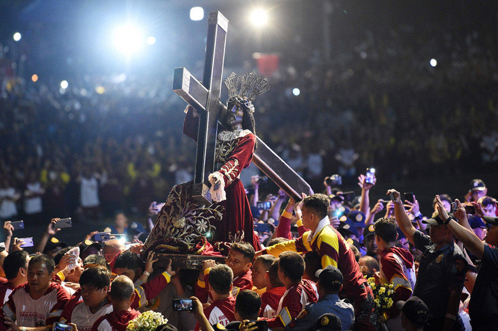 Dalam Festival Black Nazarene, patung yang bersemayam dalam sebuah lokasi di kawasan kuno Intramuros Manila, dipindahkan dengan arak-arakan ke Gereja Quiapo. Tradisi ini kerap dilakukan oleh penganut Katolik sebagai ungkapan penghormatan pada relik suci. Afp Photo/Ted Aljibe