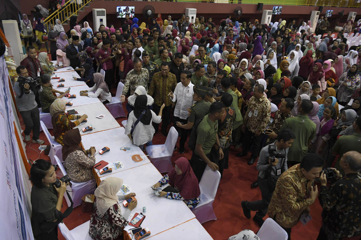 Presiden Joko Widodo didampingi Menteri Sosial Agus Gumiwang Kartasasmita dan Dirut BNI Achmad Baiquni meninjau penyaluran Bantuan Sosial Program Keluarga Harapan di Ciracas, Jakarta.