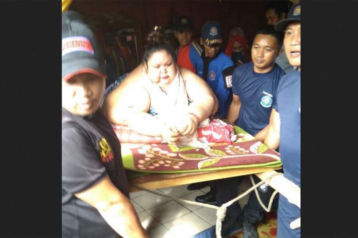 Kondisi Titi yang tak mampu lagi berjalan membuatnya harus ditandu sebanyak 20 petugas dari Damkar dan Tagana secara ekstavet melewati dua jendela rumahnya yang dijebol untuk jalur evakuasi. MI/Surya Sriyanti