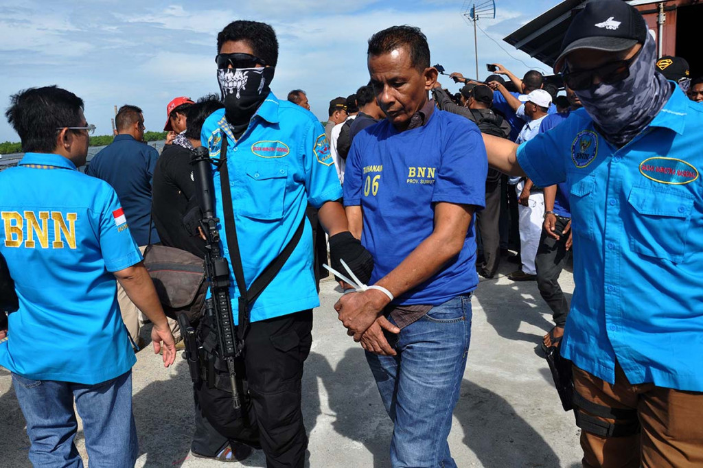 Petugas BNN menggiring seorang narapidana yang diduga sebagai pengendali penyelundupan narkoba di dermaga Bea Cukai Pelabuhan Belawan, Medan, Sumatera Utara.