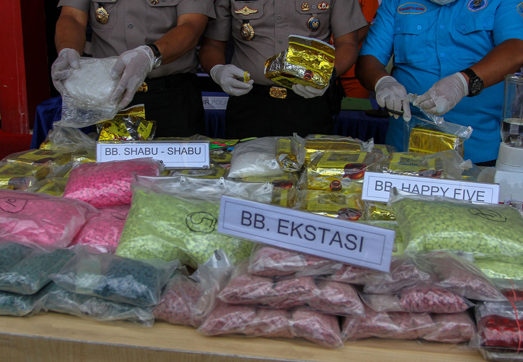 Petugas Kepolisian Daerah Riau menunjukkan barang bukti kasus narkoba berupa sabu-sabu, ekstasi dan happy five yang berhasil ditangkap dari pengedar jaringan internasional di perairan Bengkalis ketika konferensi pers di Mapolda Riau, Pekanbaru, Riau.