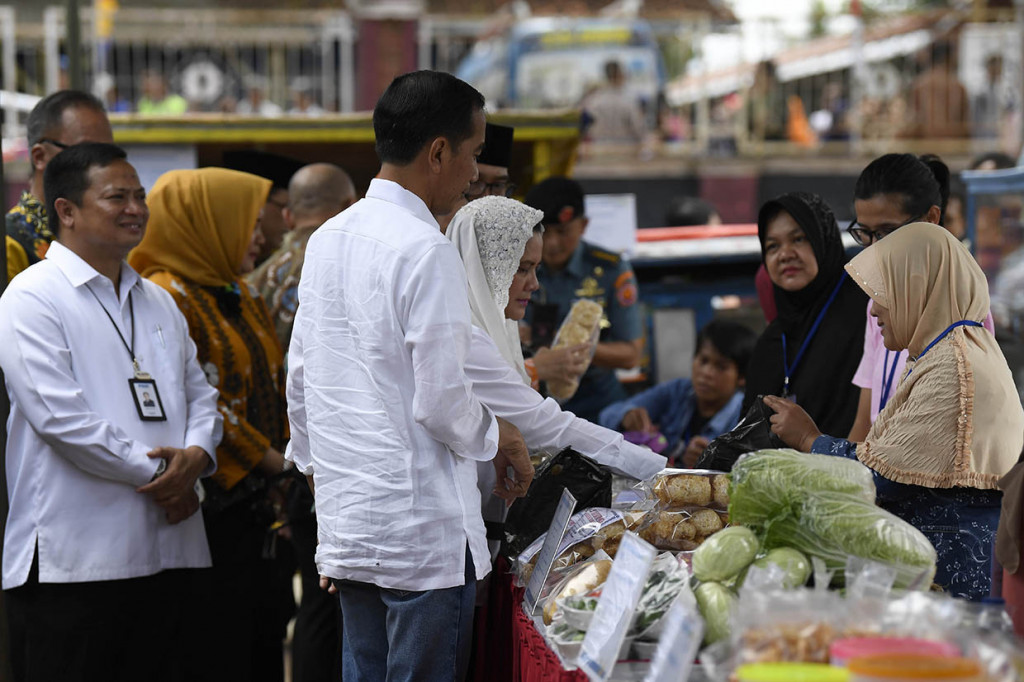 Presiden Joko Widodo (tengah) didampingi Ibu Negara Iriana Joko Widodo meninjau Program Mekaar binaan PNM di Kampung Pasar Kolot, Garut, Jawa Barat.