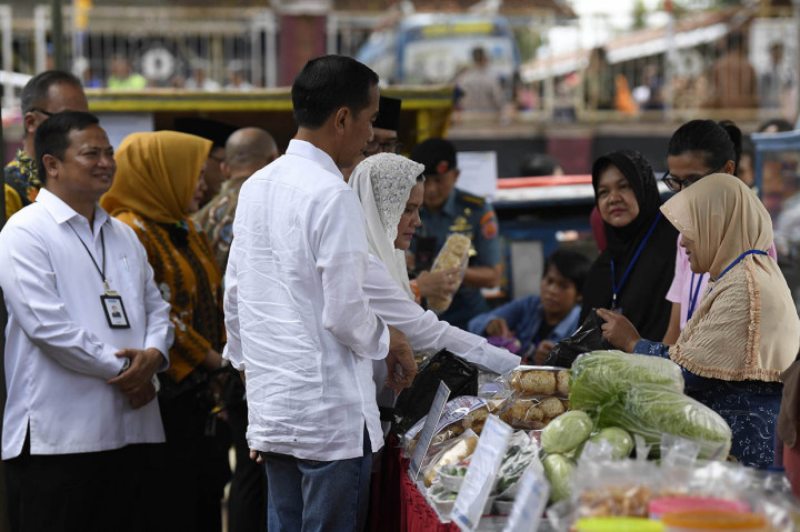 Presiden Joko Widodo (tengah) didampingi Ibu Negara Iriana Joko Widodo meninjau Program Mekaar binaan PNM di Kampung Pasar Kolot, Garut, Jawa Barat.