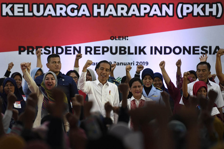 Presiden Joko Widodo (tengah) bersama Ibu Negara Iriana Joko Widodo (ketiga kanan) menyanyikan mars Program Keluarga Harapan (PKH) di Garut, Jawa Barat. 