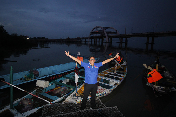 Calon Wakil Presiden nomor urut 02 Sandiaga Salahuddin Uno melihat perahu nelayan di dekat  Jembatan Suroboyo saat berkunjung ke Kampung Nelayan Sukolilo, Surabaya, Jawa Timur.