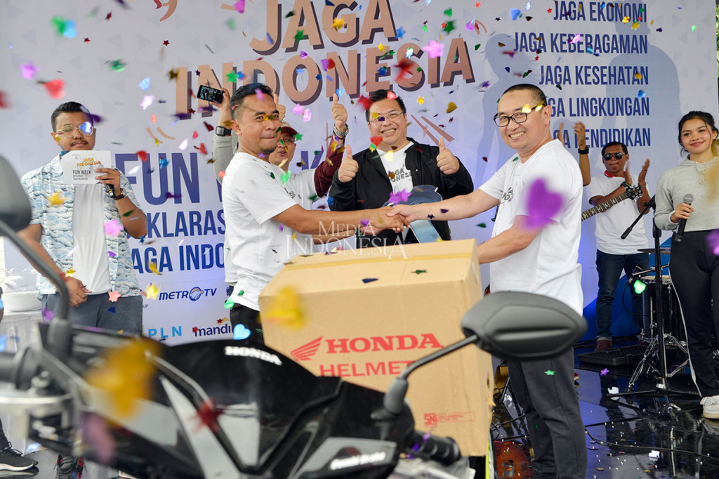 Direktur Utama MI Firdaus Dayat (kanan) menyerahkan hadiah utama jalan santai pada peringatan hari jadi Media Indonesia yang jatuh pada 19 Januari, pada acara fun walk di pelataran parkir Sarinah, Thamrin, Jakarta.