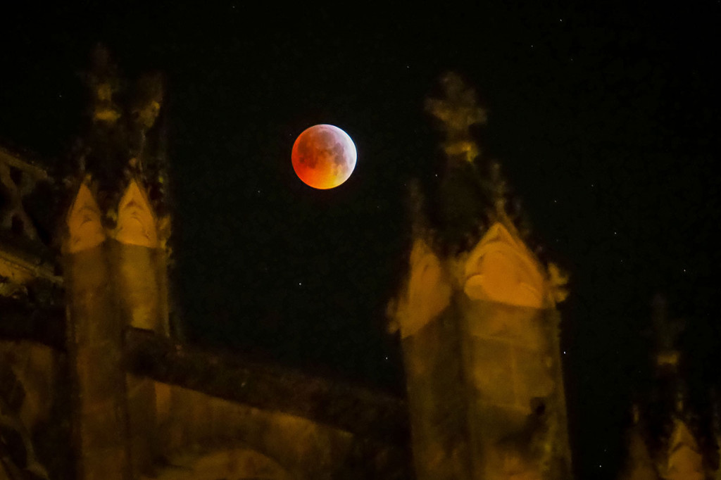 Fenomena super blood wolf moon terlihat di antara bangunan Katedral Tours, di Paris, Prancis. AFP Photo/Guillaume Souvant