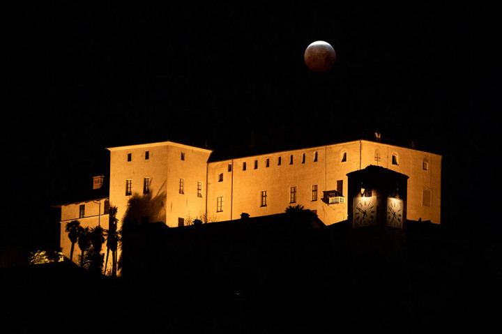 Penampakan super blood wolf moon di atas Castello della Manta, di Manta, dekat Cuneo, barat laut Italia. AFP Photo/Marco Bertorello