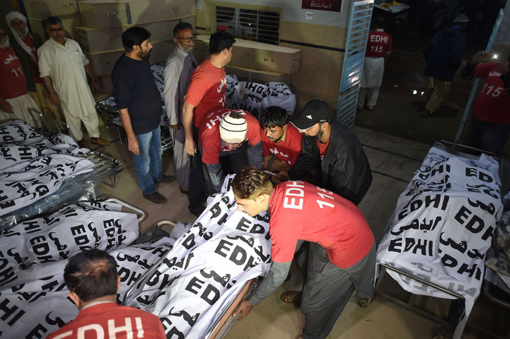 Sukarelawan menangani puluhan korban tewas terbakarnya bus di kamar jenazah Edhi Foundation, Karachi, Selasa, 22 Januari 2019.
