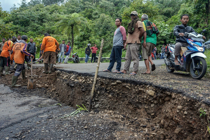 Sejumlah pekerja memperbaiki jalan yang ambles di Desa Tenogo, Paninggaran, Kabupaten Pekalongan, Jawa Tengah.