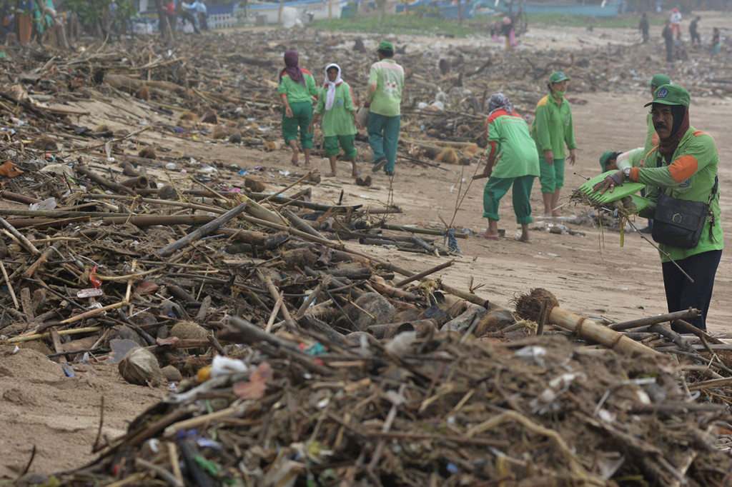 Sejumlah petugas membersihkan tumpukan sampah yang berserakan di kawasan Pantai Kuta, Badung, Bali.