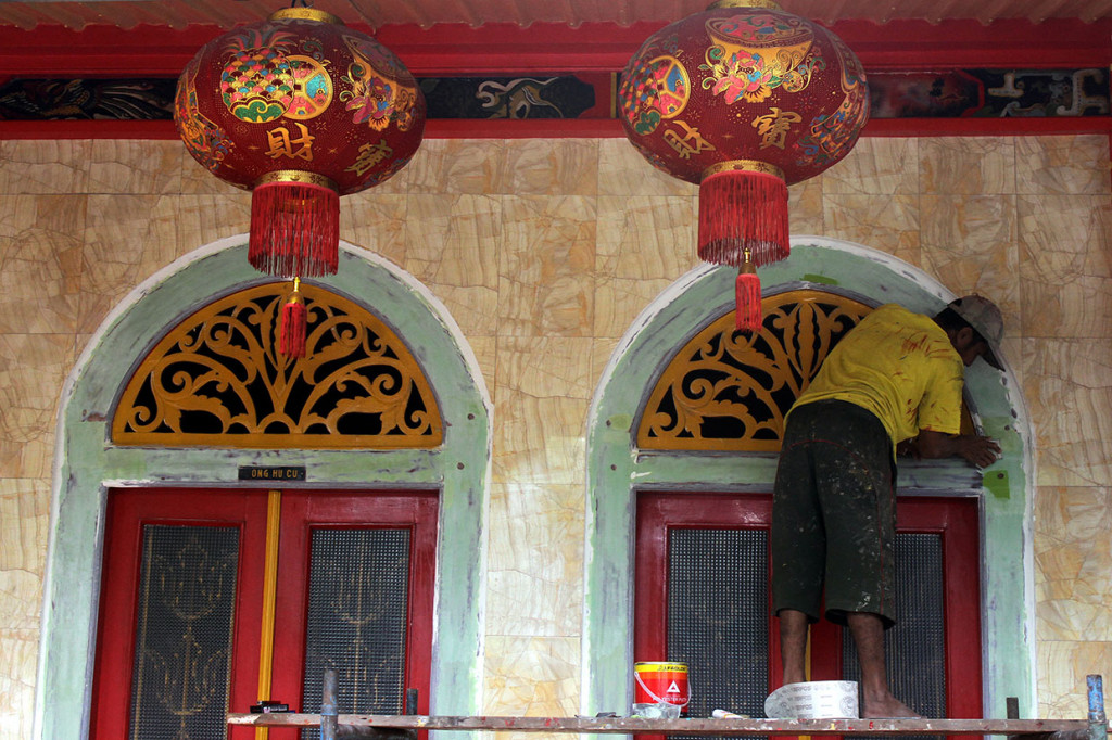 Pekerja mengecat ornamen di Kelenteng En Ang Kiong, Malang, Jawa Timur. Antara Foto/Ari Bowo Sucipto
