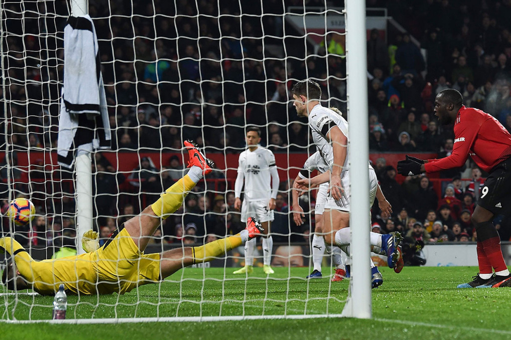 Kiper Burnley Tom Heaton melakukan penyelamatan gemilang dengan menepis sontekan Romelu Lukaku.