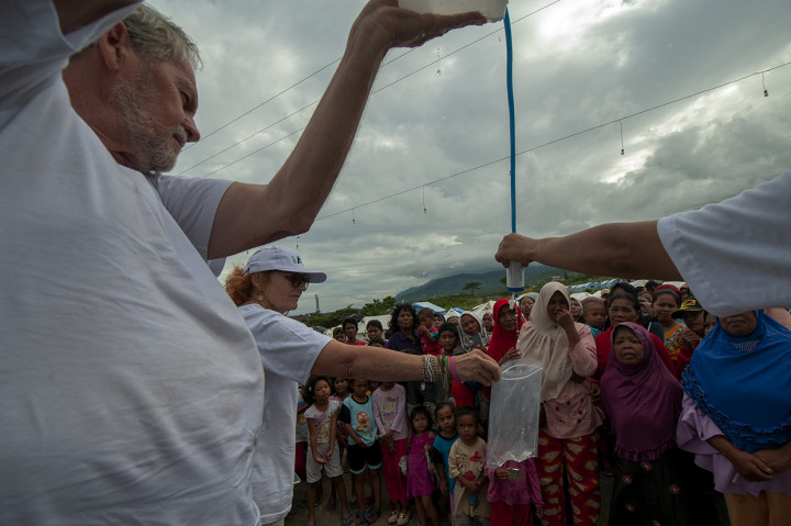 Aktivis lembaga kemanusiaan internasional iAID memperagakan penggunaan alat penyuling air minum kepada korban gempa di Kamp Pengungsian Kelurahan Duyu, Palu, Sulawesi Tengah.
