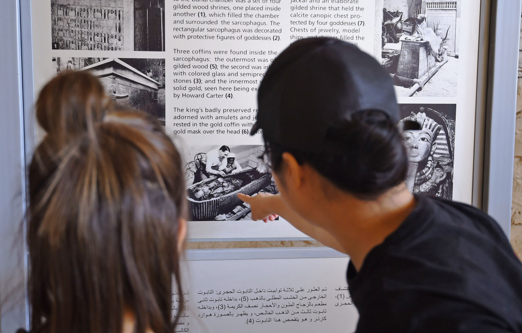Sepasang wisatawan menyaksikan kliping tentang penemuan dan penggalian piramida Tut Ankh Amun. Sebuah museum khusus akan dibangun untuk memamerkan benda-benda temuan dalam piramida.