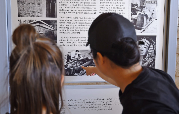 Sepasang wisatawan menyaksikan kliping tentang penemuan dan penggalian piramida Tut Ankh Amun. Sebuah museum khusus akan dibangun untuk memamerkan benda-benda temuan dalam piramida.
