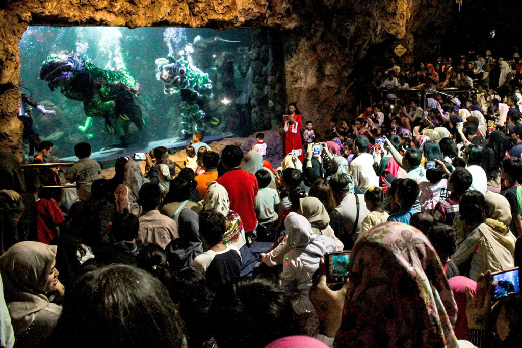 Puluhan pengunjung antusias menyaksikan pertunjukan barongsai di dalam air di Seaworld Ancol, Jakarta, Minggu, 3 Februari 2019. 