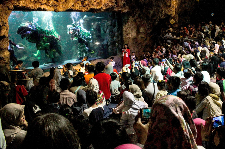 Puluhan pengunjung antusias menyaksikan pertunjukan barongsai di dalam air di Seaworld Ancol, Jakarta, Minggu, 3 Februari 2019. 