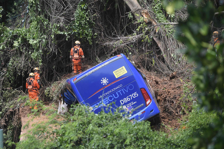 Petugas berusaha mengevakuasi badan bus yang tertimpa longsor pascabadai menerjang wilayah Rio de Janeiro, Brasil, Kamis, 7 Februari 2019 waktu setempat.