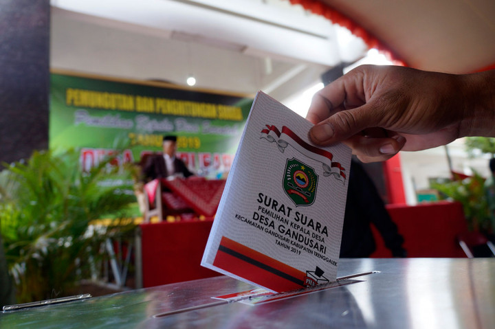 Pemilih memasukkan surat suara yang telah dicoblos ke dalam kotak suara di TPS Pilkades Desa Gandusari, Trenggalek, Jawa Timur, Sabtu, 9 Februari 2019.