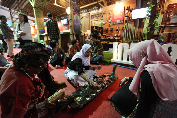 Pengunjung mencoba permainan tradisional Congklak ketika acara pameran pada Rembuknas Kemdikbud 2019.
