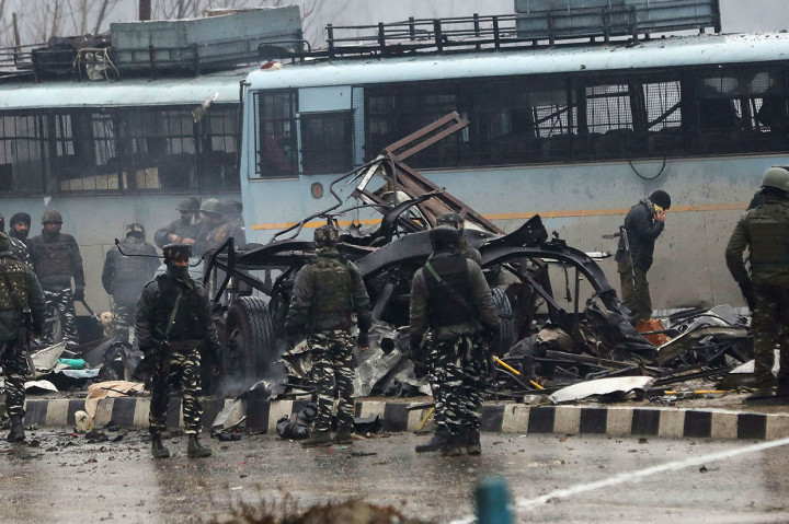 Pasukan keamanan India memeriksa puing-puing sebuah kendaraan menyusul serangan bom pinggir jalan yang dilalui rombongan pasukan keamanan di Srinagar, India, Kamis, 14 Februari 2019.