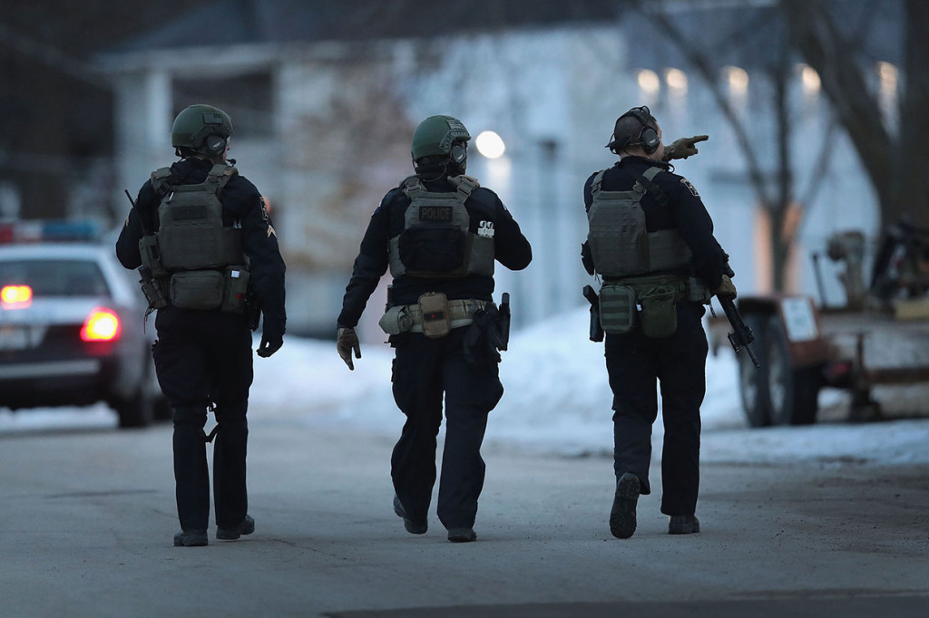 Polisi bersenjata lengkap mengamankan area setelah terjadi penembakan di kawasan industri Henry Pratt Company, Aurora, Illinois, Kamis, 15 Februari 2019 waktu setempat.