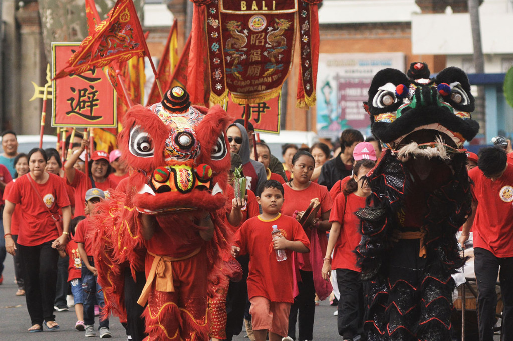 Sejumlah warga etnis Tionghoa berkeliling kampung saat kirab perayaan Cap Go Meh di kawasan Ubung Kaja, Denpasar, Bali. Kirab tersebut dilakukan untuk memberikan keseimbangan kepada alam semesta sekaligus menetralisir energi negatif. Antara Foto/Fikri Yusuf